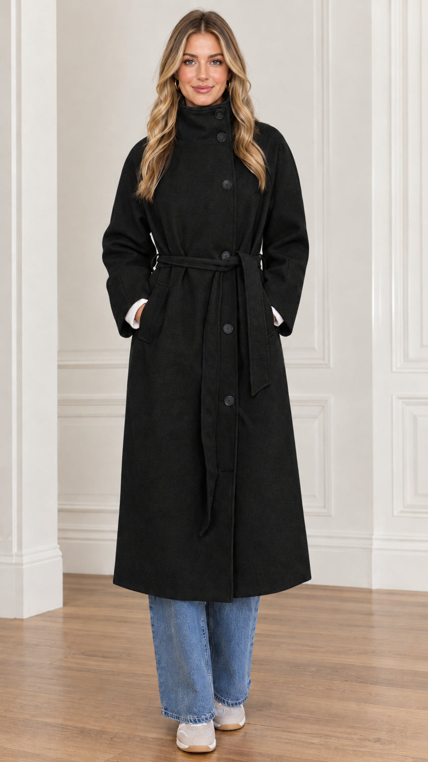 Front view of woman wearing black long belted high neck overcoat