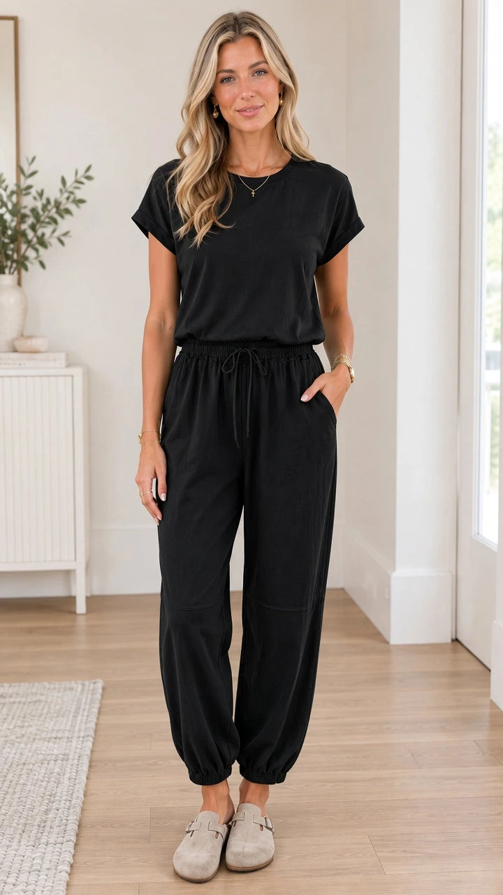 Front full view of woman wearing black short sleeve casual jogger jumpsuit