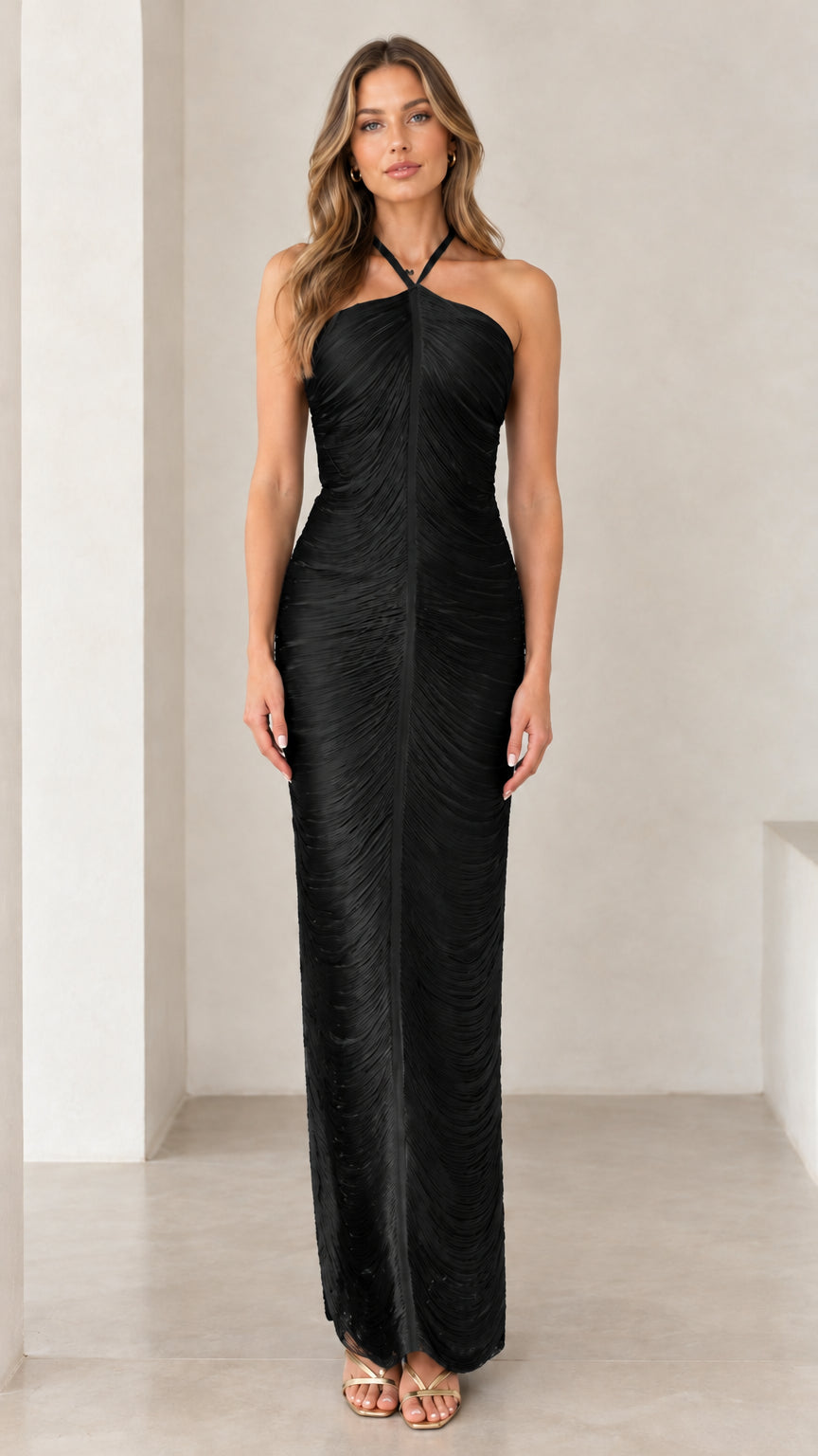 Front view of woman wearing black halter ruched backless maxi dress
