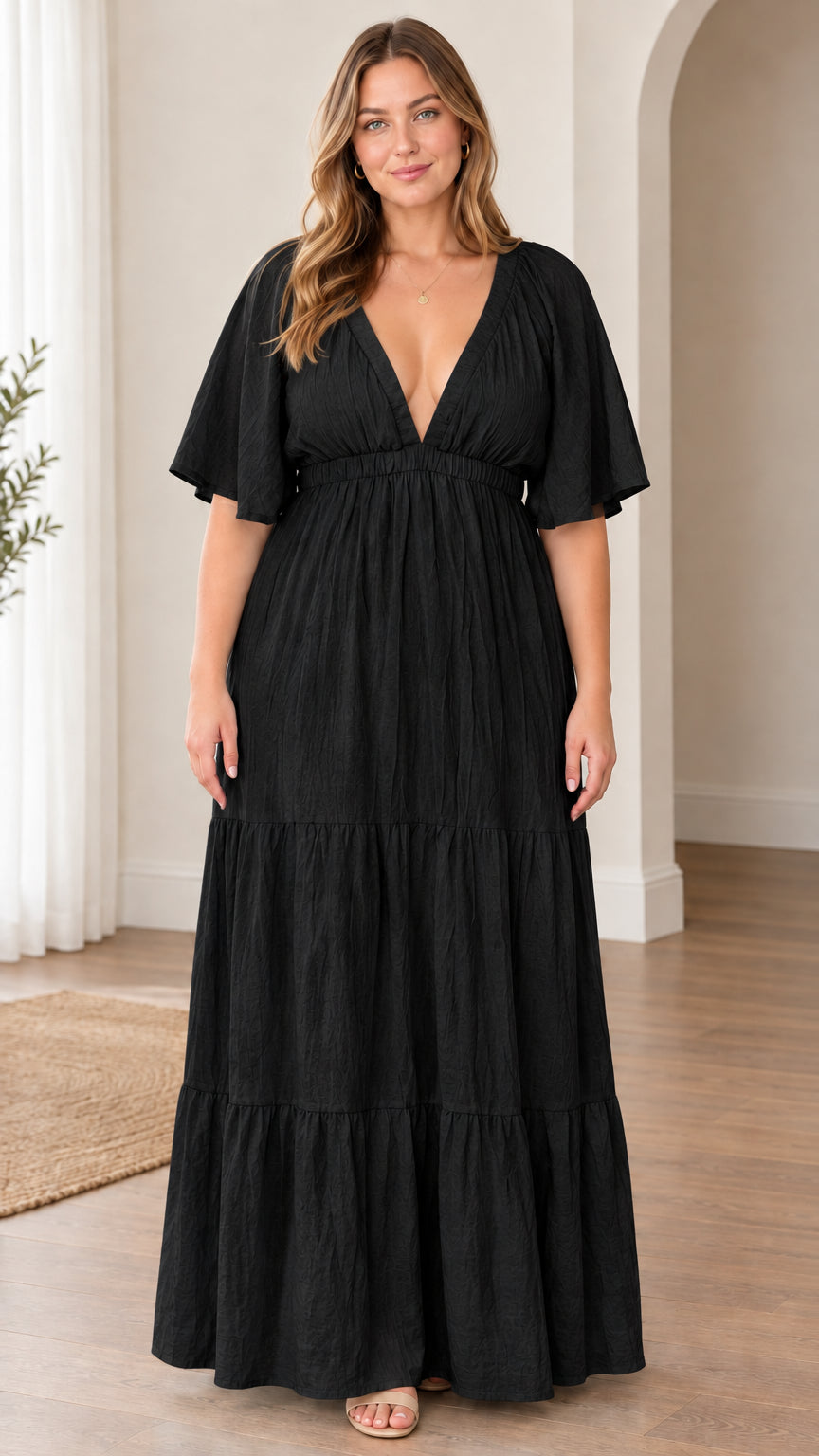 Model wearing black plunge V-neck tiered maxi dress with flutter sleeves