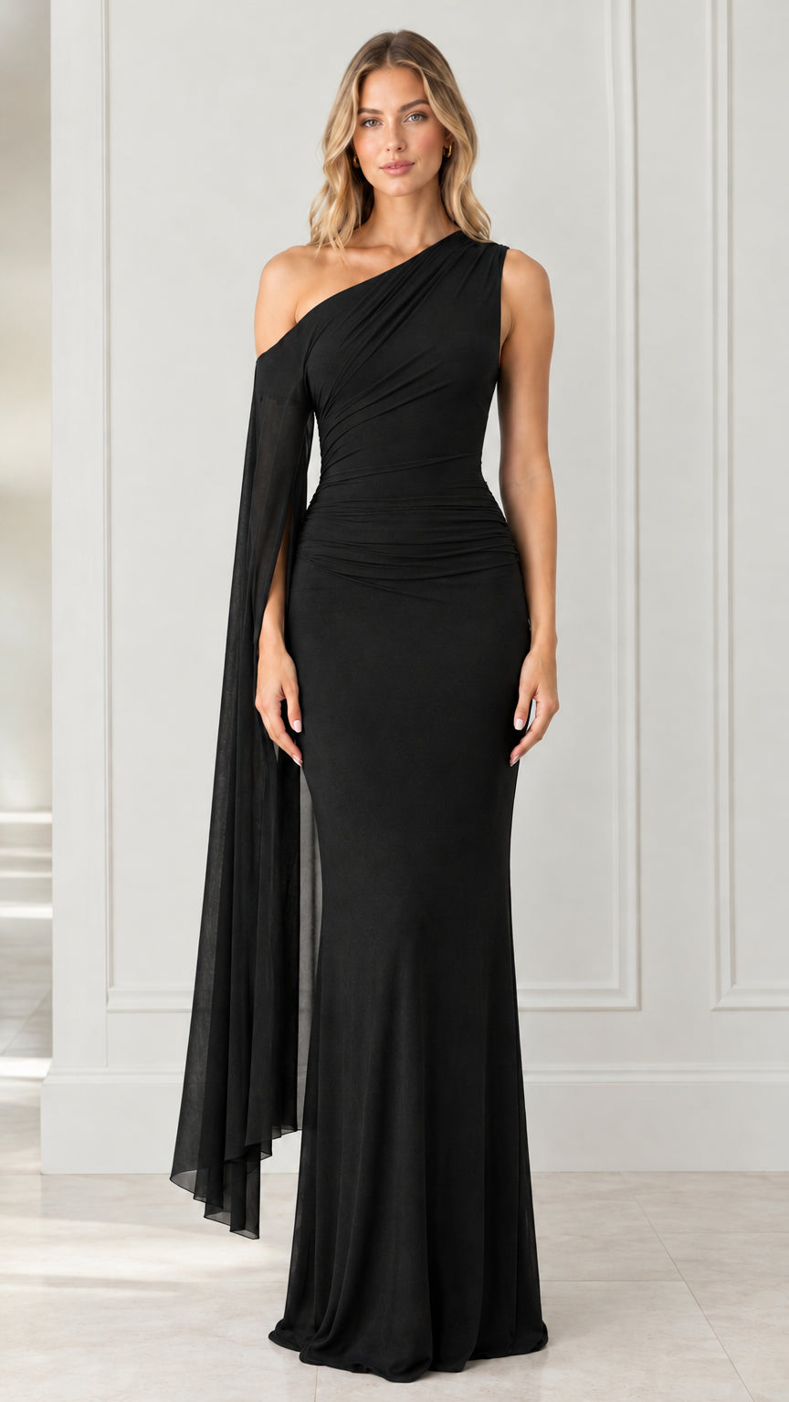 Front full-length view of black one-shoulder ruched evening gown with cape drape