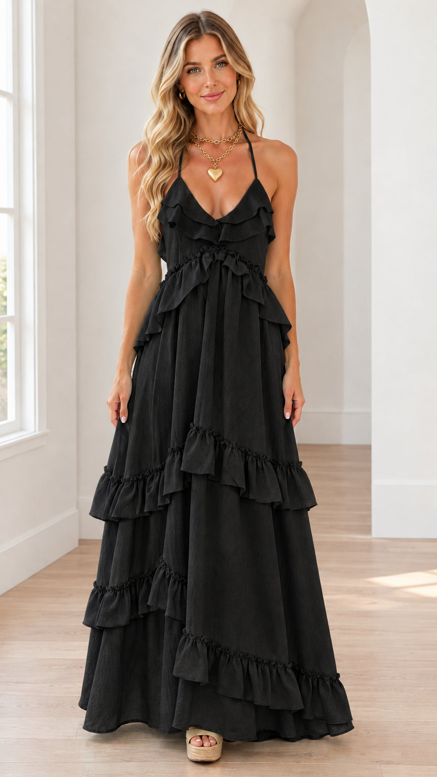 Front view of black tiered ruffle halter maxi dress on model