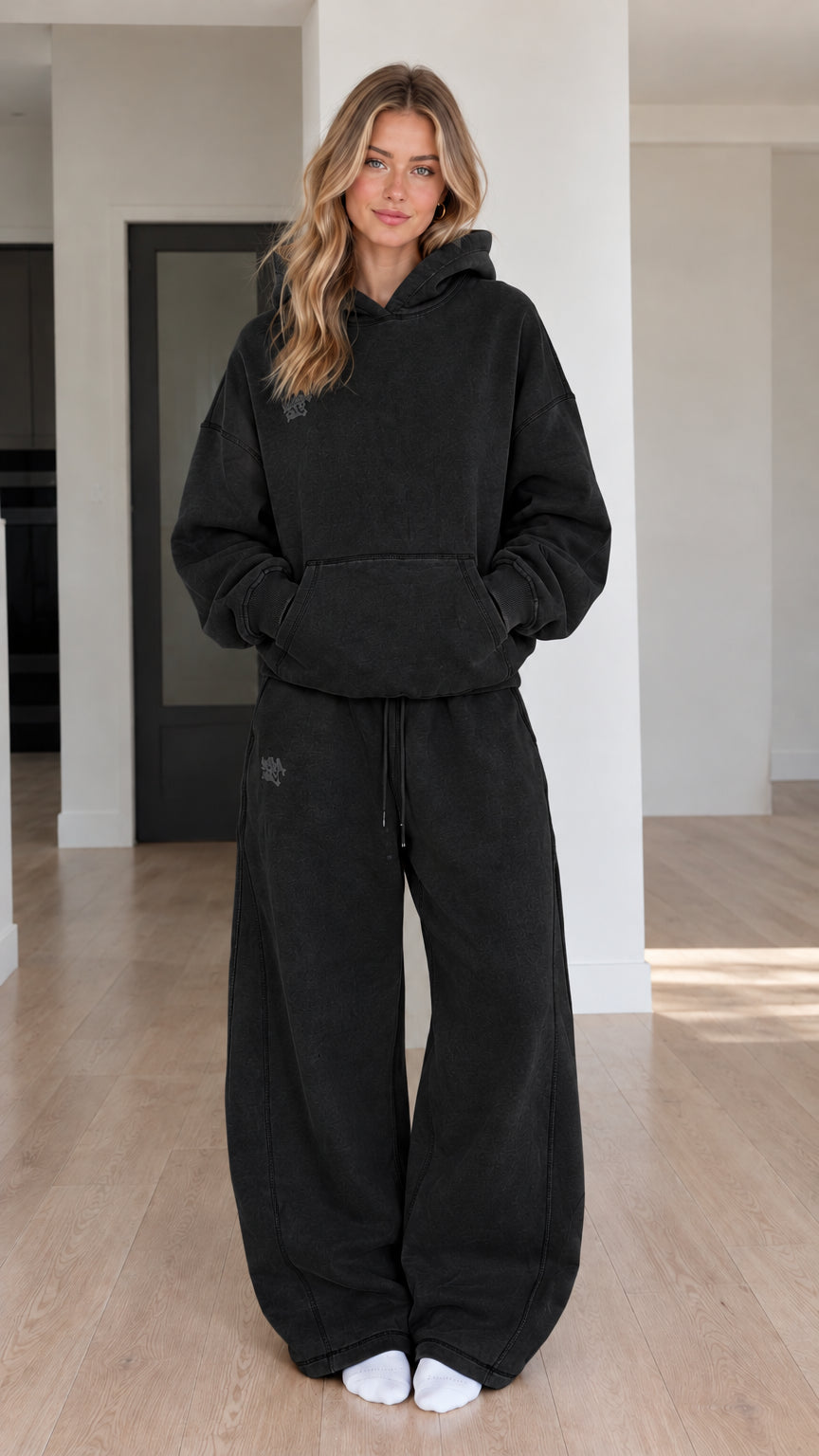 Front view of model wearing Black oversized hoodie and wide-leg sweatpants set