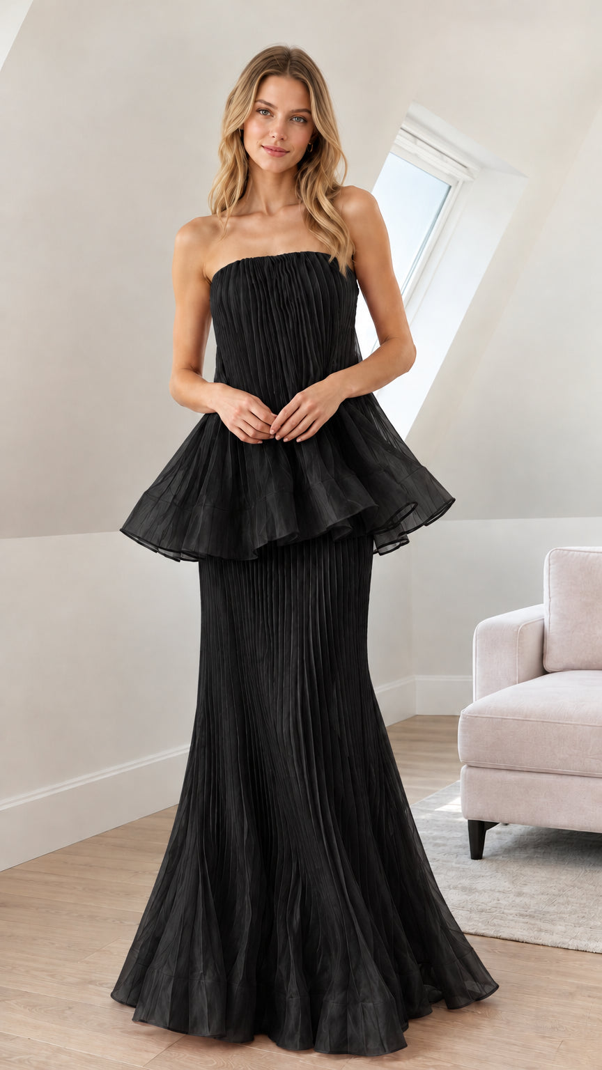 Front view of woman wearing black strapless pleated peplum maxi dress