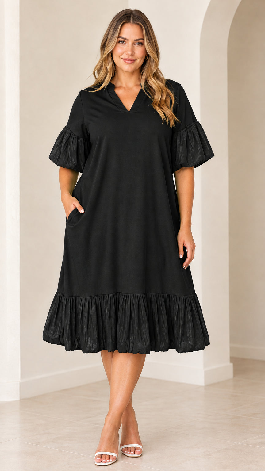 Model wearing black V-neck flutter sleeve midi dress with side pockets