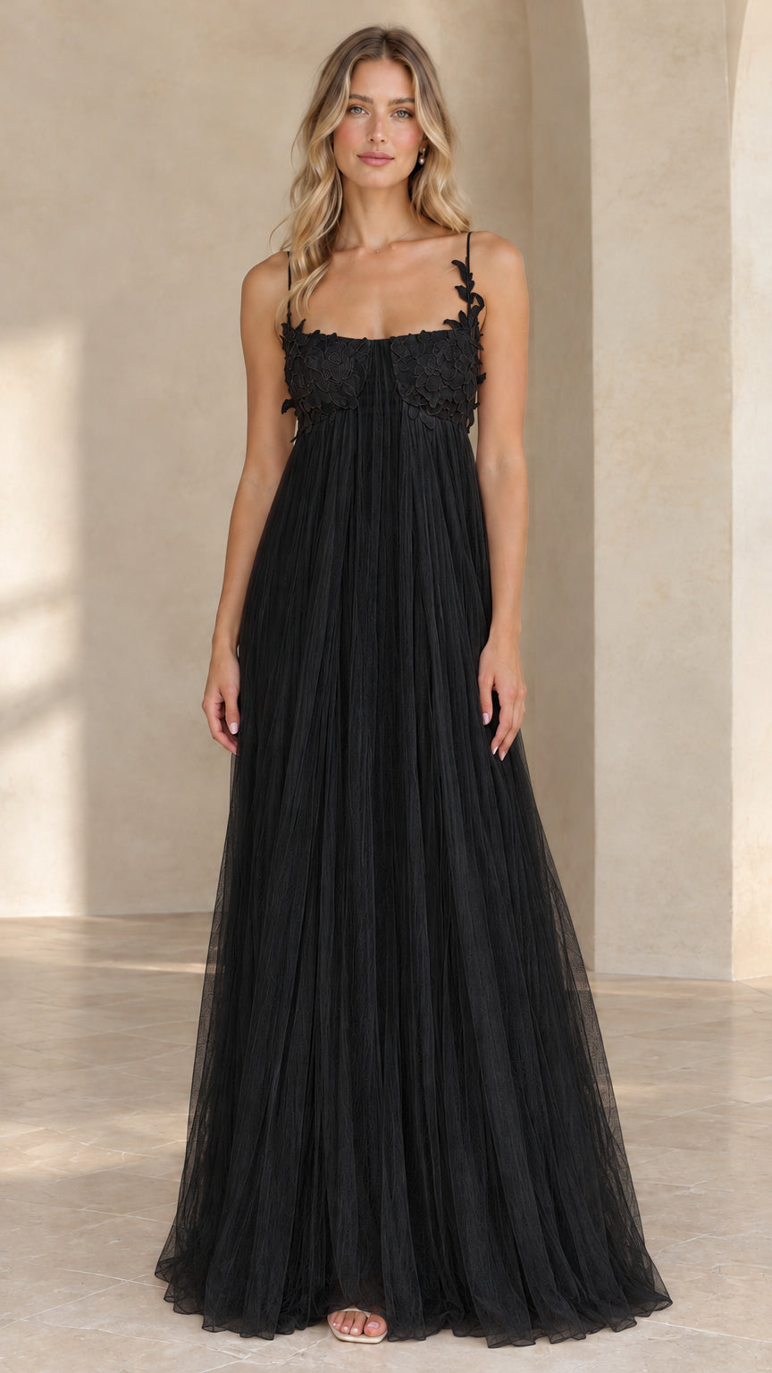 Full length view of black pleated tulle maxi evening gown with floral applique bodice