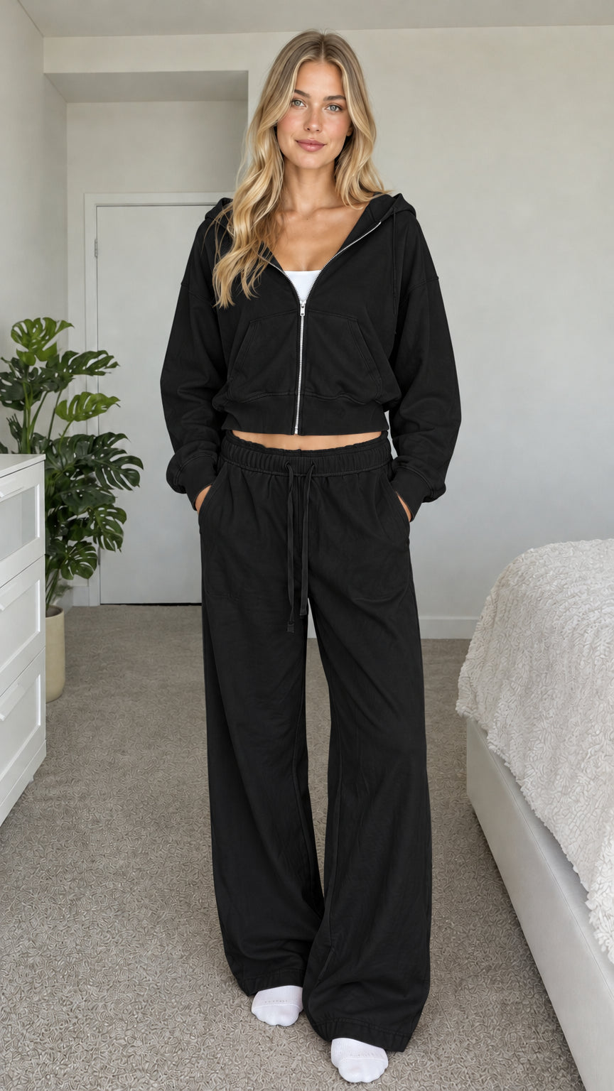 Model wearing black cropped zip hoodie and wide-leg sweatpants set
