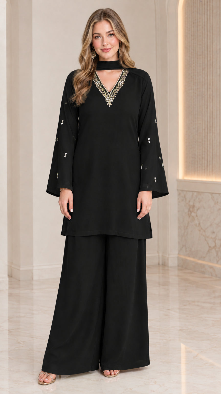 Front full-length view of model wearing black embellished tunic and wide-leg pant set