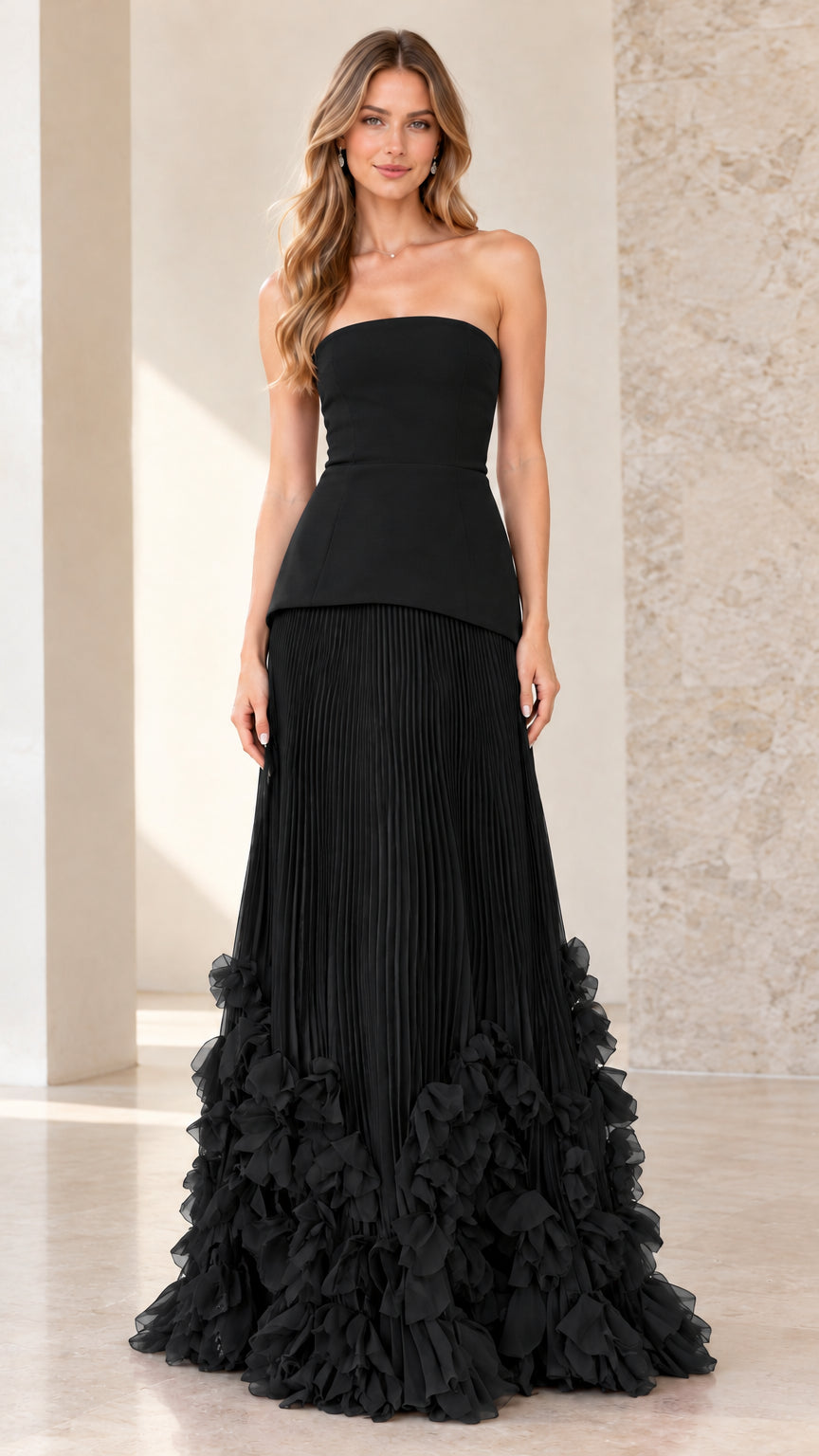 Front view of model wearing black strapless peplum pleated evening gown