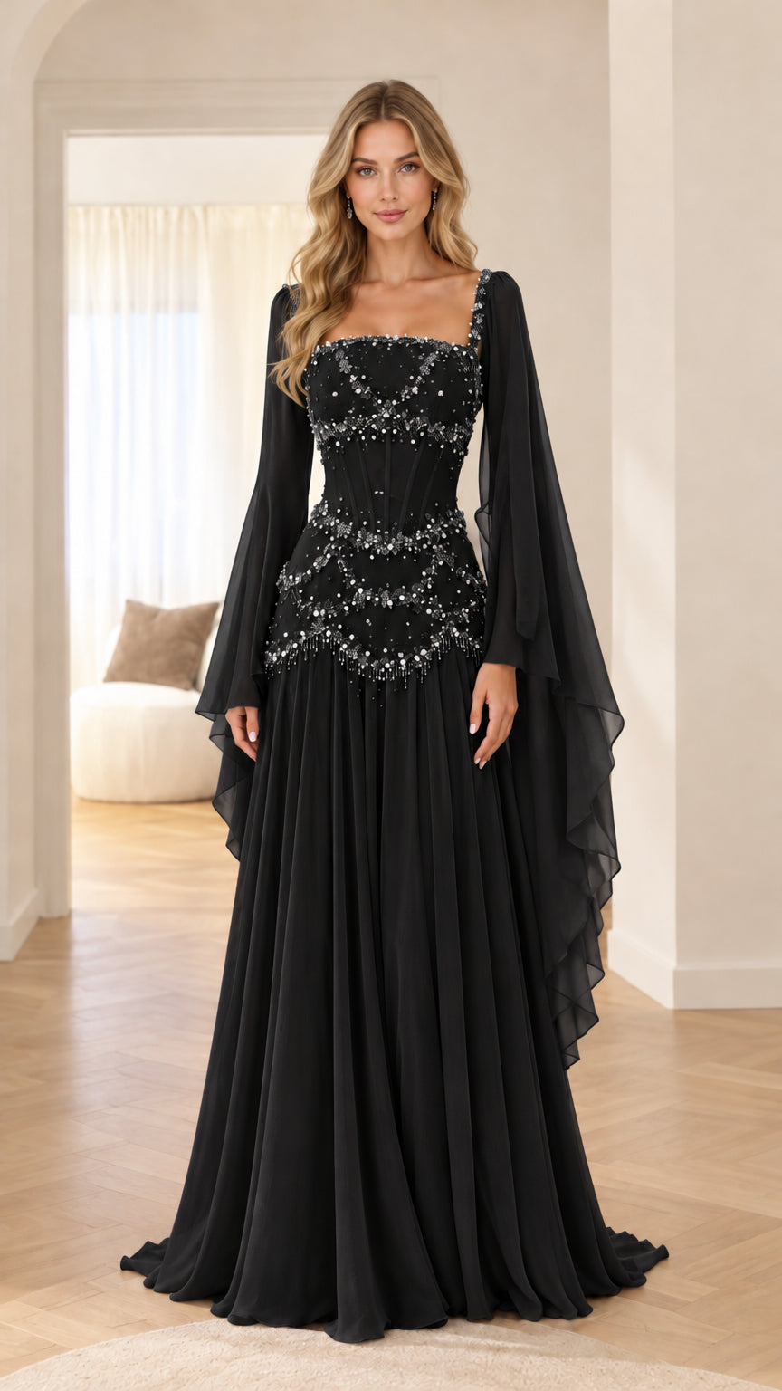 Front view of model wearing black embellished corset maxi gown with draped cape sleeves