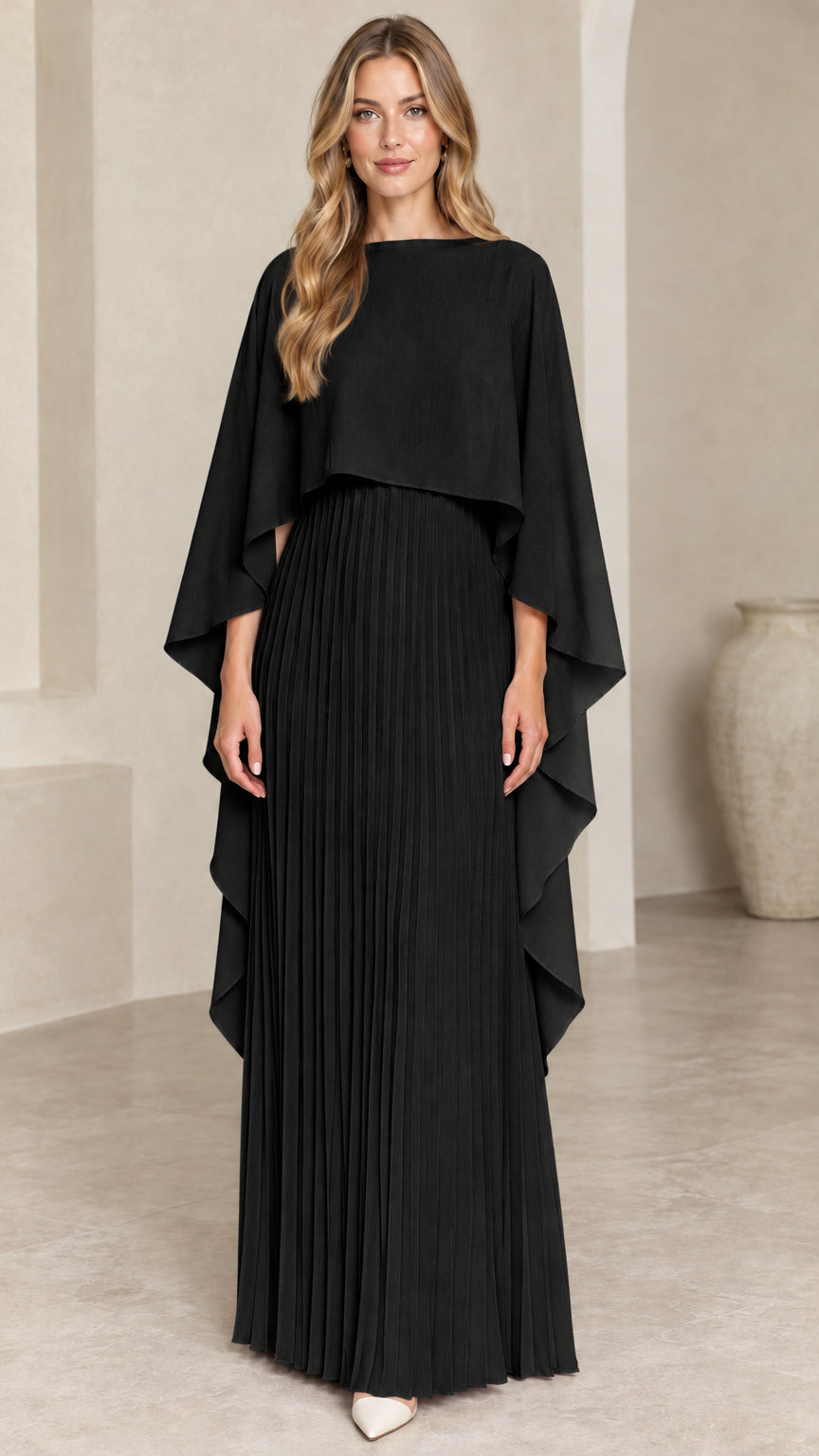 Front view of woman wearing black pleated cape maxi dress
