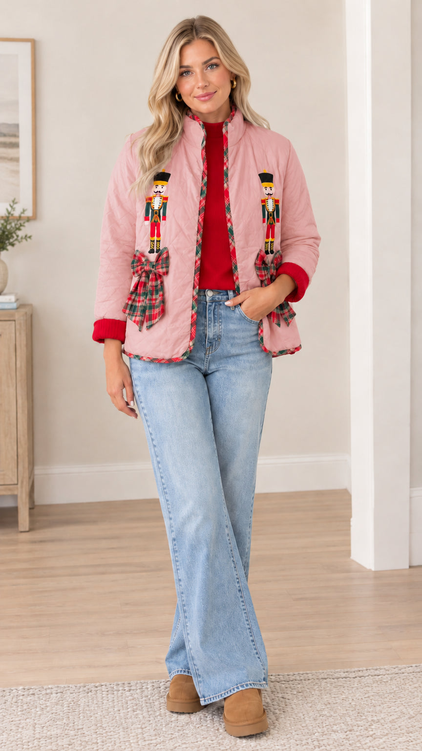Model wearing pink quilted holiday jacket with nutcracker embroidery