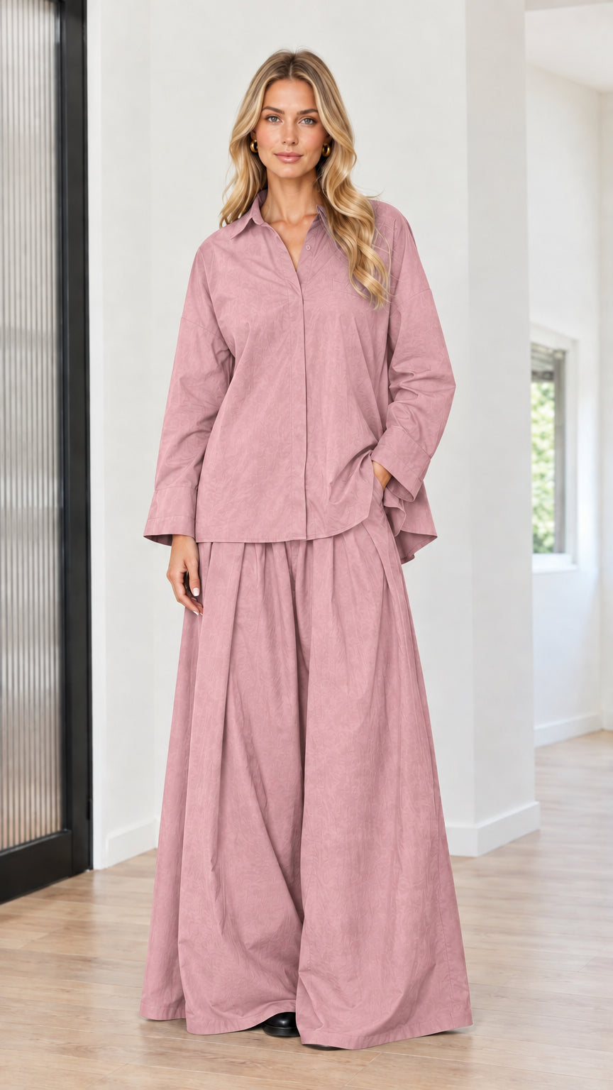 Model wearing dusty pink button-down tunic shirt and pleated palazzo trousers set