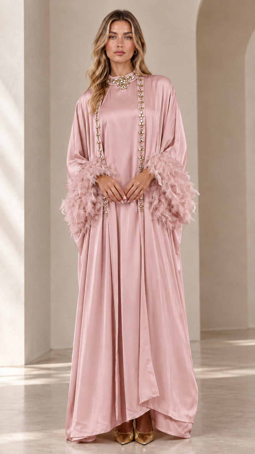 Front view of woman wearing blush pink satin embellished maxi kaftan with feather cuffs
