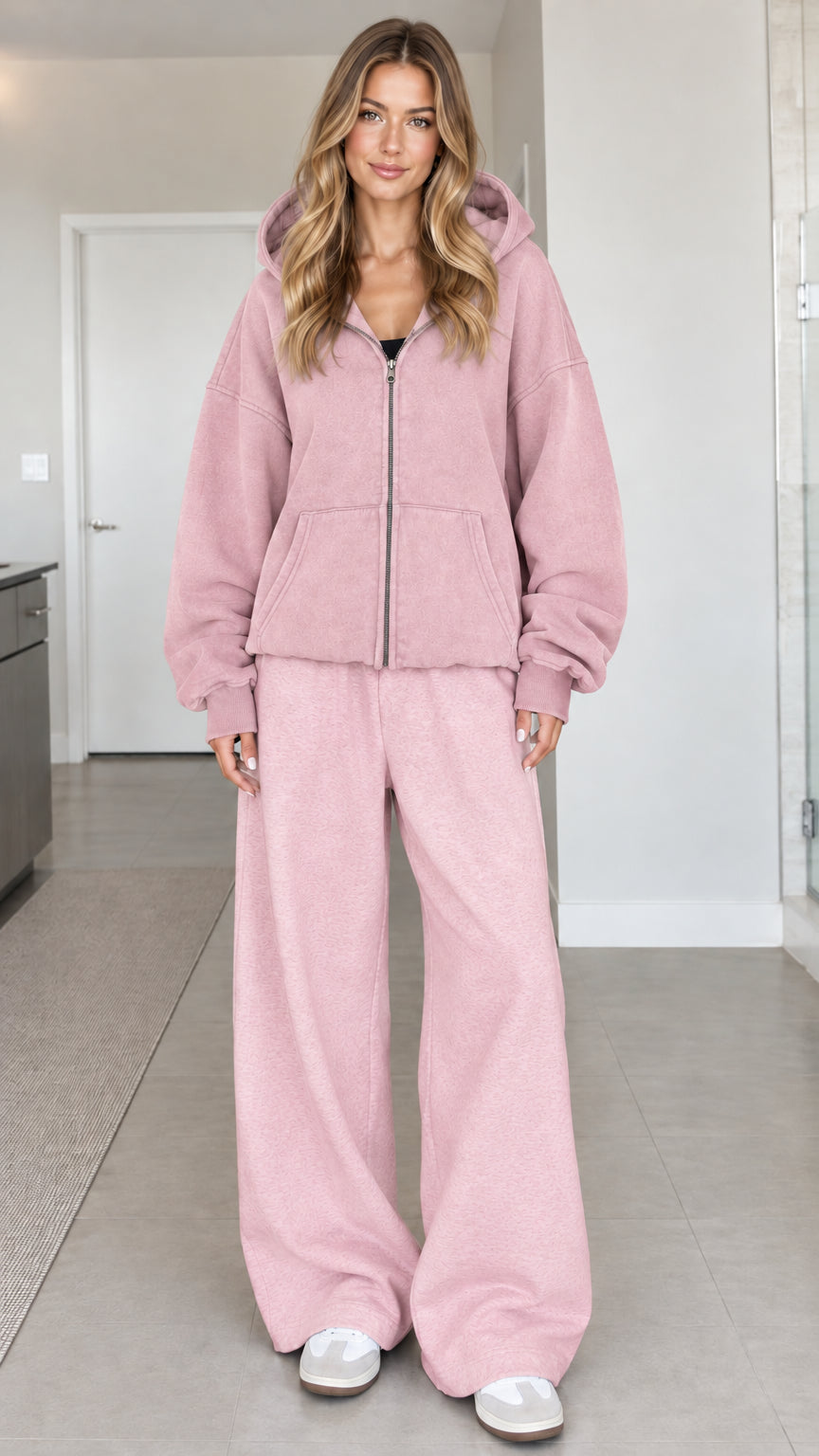 Front view of a woman wearing an oversized dusty pink zip-up hoodie with matching pink lounge pants