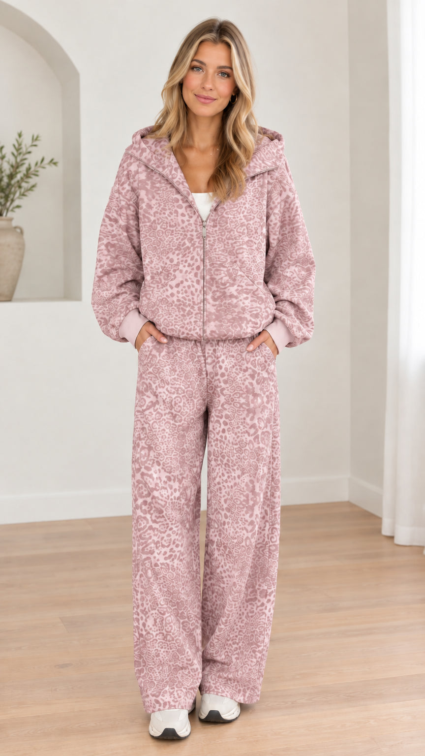 Woman wearing dusty pink leopard print hooded zip-up jacket and wide-leg pants set