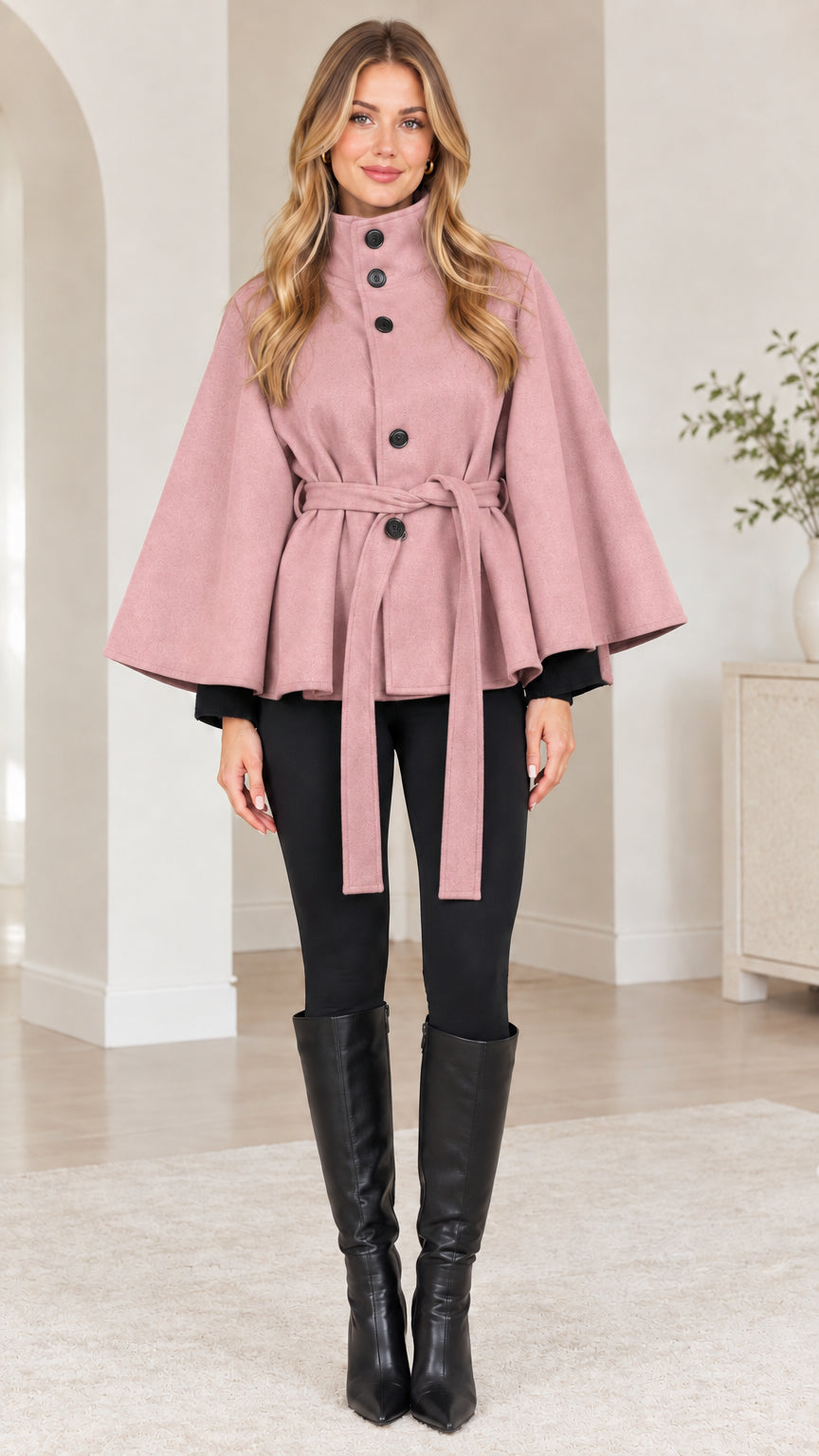 Front view of woman wearing dusty pink belted cape coat with stand collar