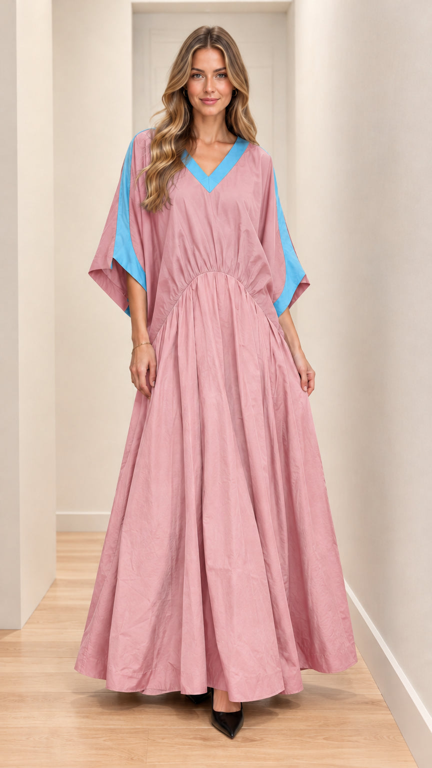 Front full-length view of model wearing pink maxi dress with blue contrast trim