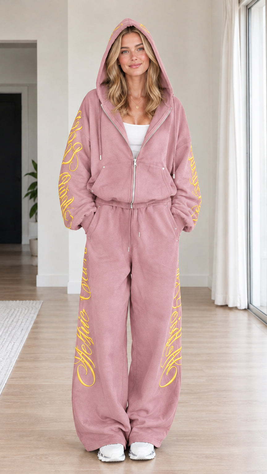 Front view of woman wearing dusty pink script embroidered zip-up hoodie and wide-leg sweatpants set