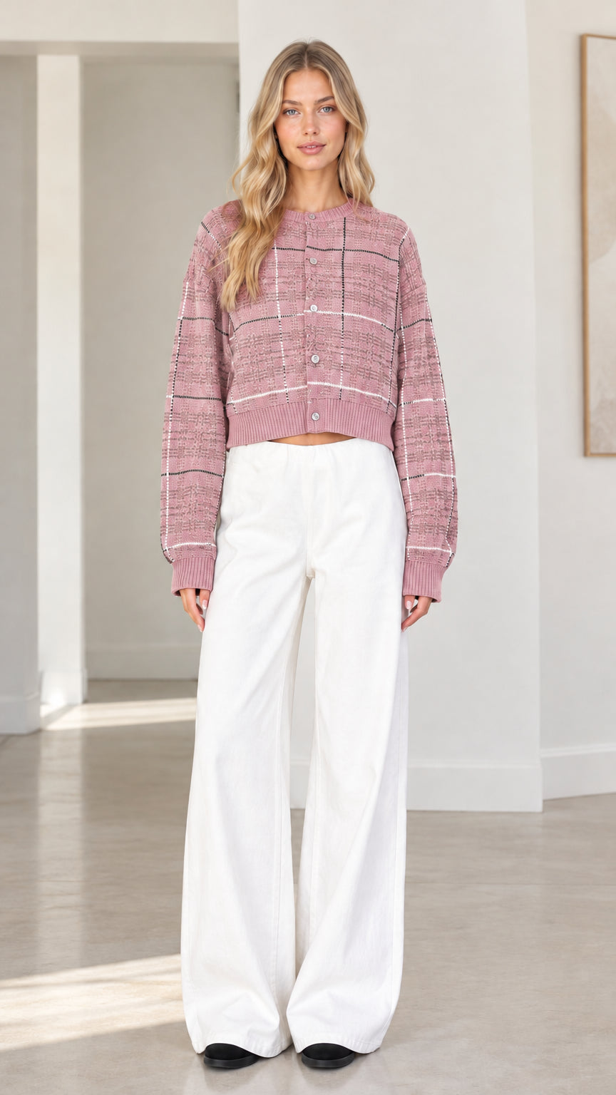 Front view of woman wearing dusty pink plaid cropped cardigan sweater with white wide-leg trousers