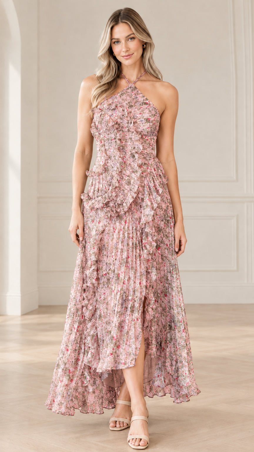 Front full-length view of model wearing blush pink floral halter neck pleated maxi dress