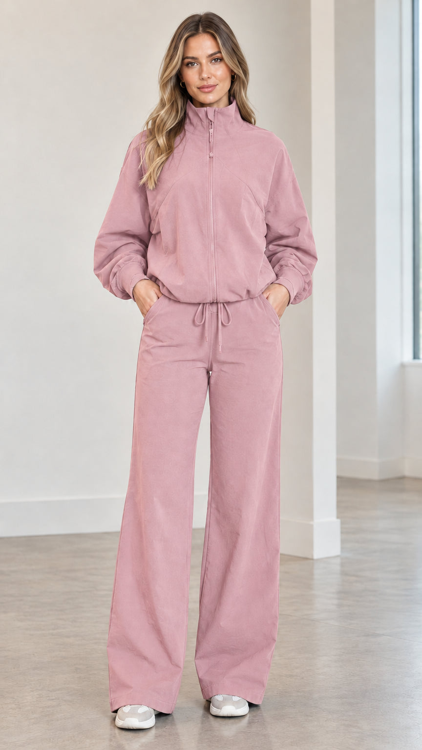 Front full view of woman wearing dusty pink zip-up track jacket and matching wide-leg pants