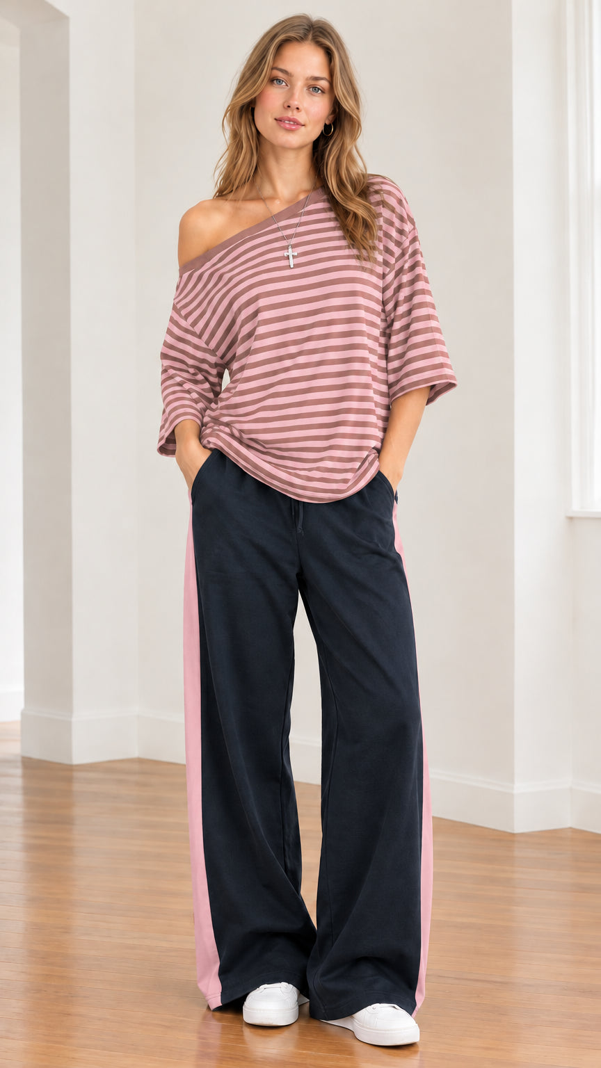Model wearing dusty pink striped one-shoulder top with coordinating side-stripe trousers
