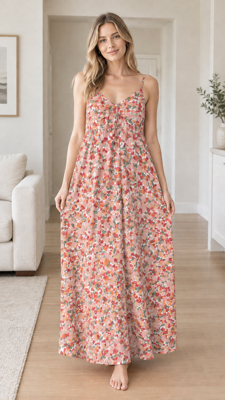 Front view of woman wearing pink floral spaghetti strap backless maxi dress