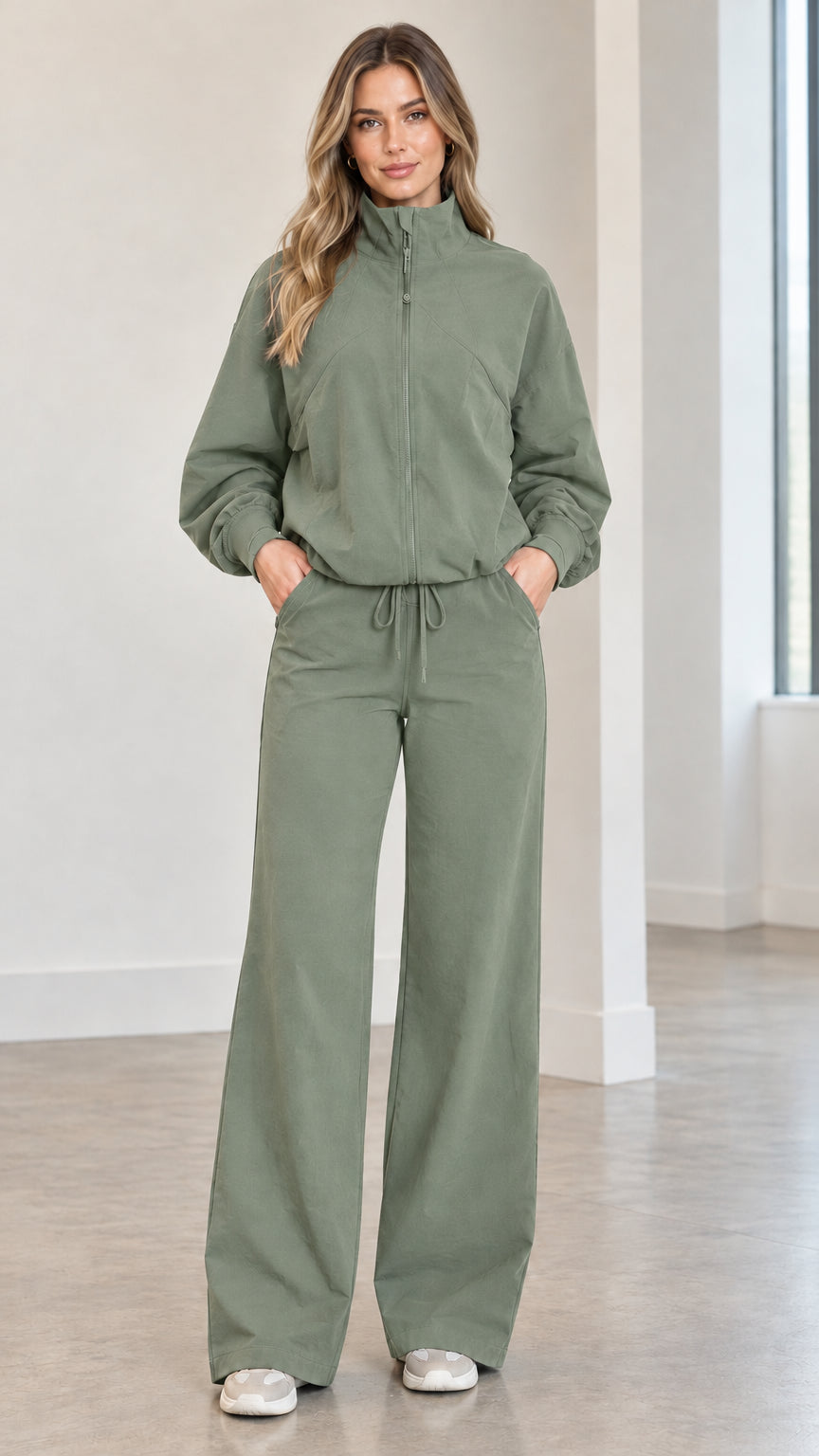 Front full view of woman wearing sage green zip-up track jacket and matching wide-leg pants