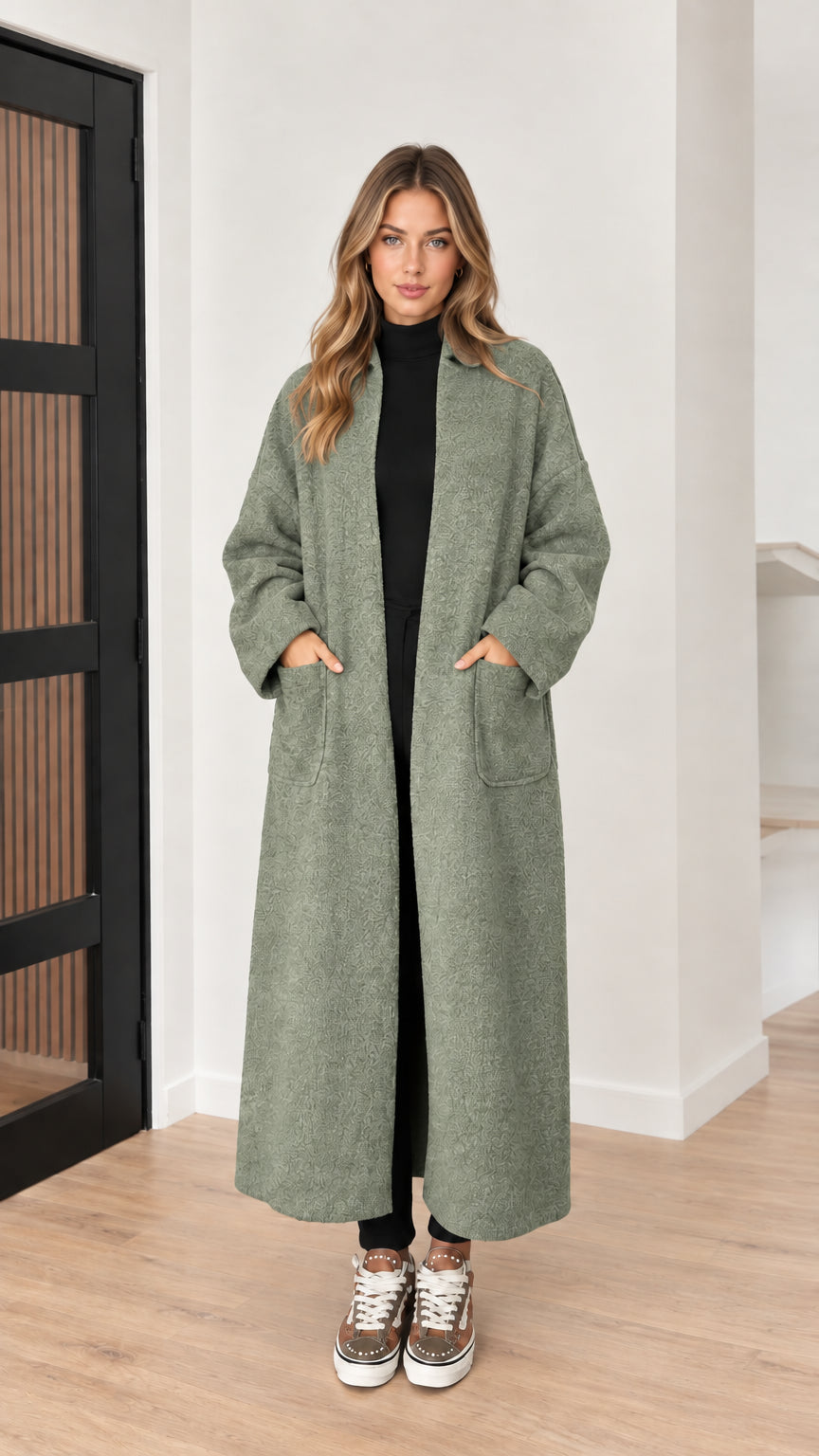 Front view of model wearing sage green textured maxi coat