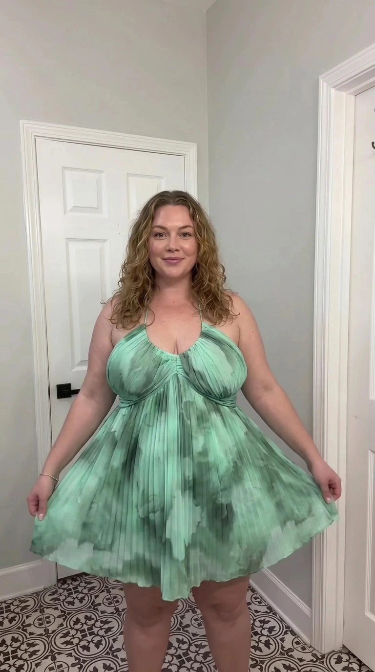 Front view of sage green multi watercolor pleated halter babydoll dress