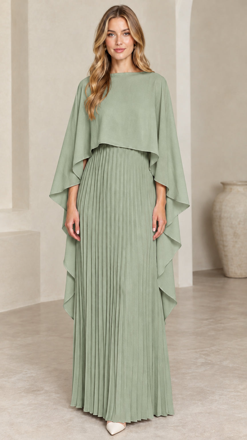 Front view of woman wearing sage green pleated cape maxi dress