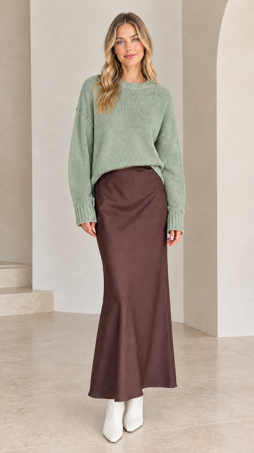 Model wearing sage green crew neck knit sweater with brown satin skirt