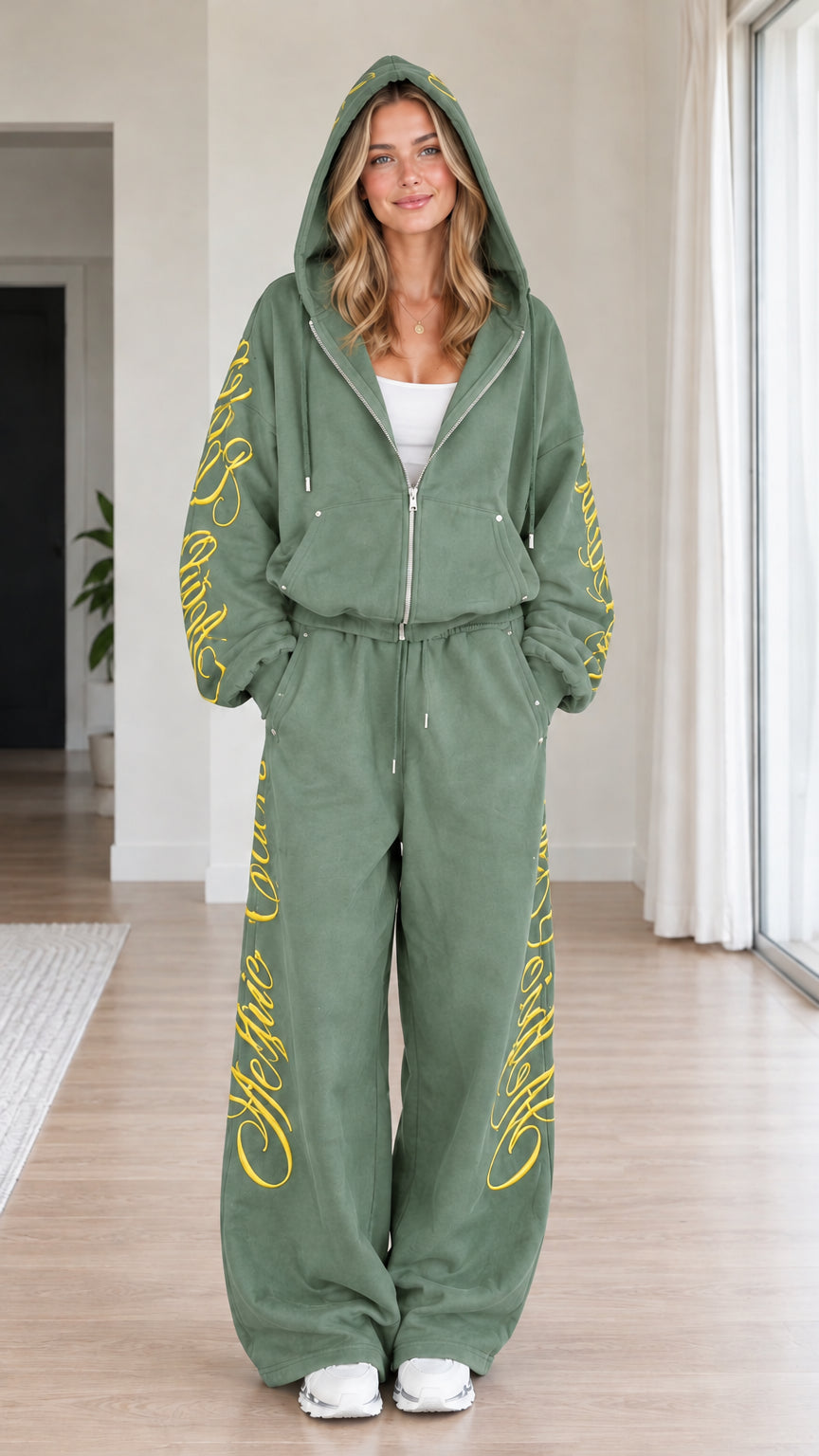 Front view of woman wearing sage green script embroidered zip-up hoodie and wide-leg sweatpants set