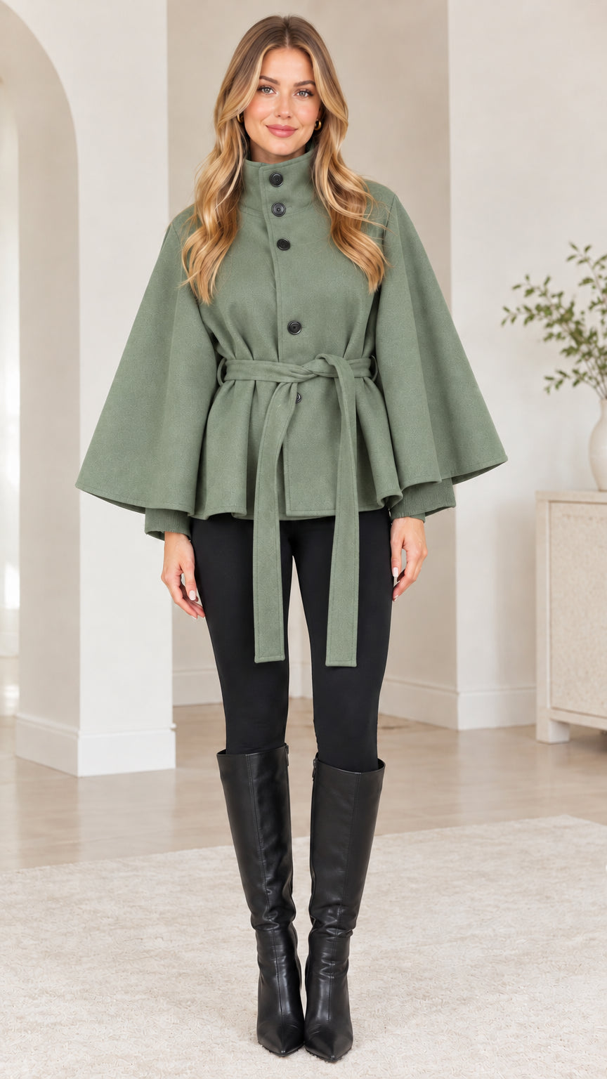 Front view of woman wearing sage green belted cape coat with flared sleeves