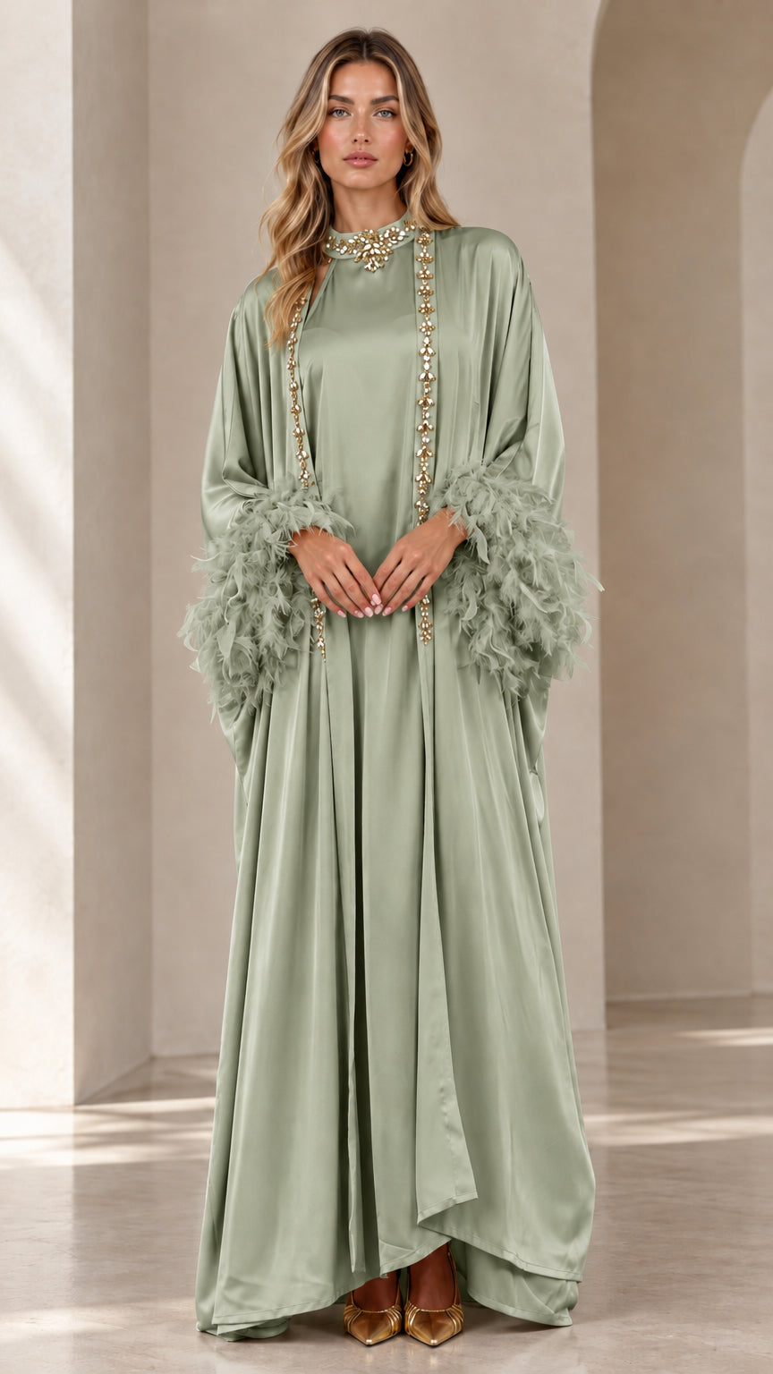 Front view of woman wearing sage green satin embellished maxi kaftan with feather cuffs