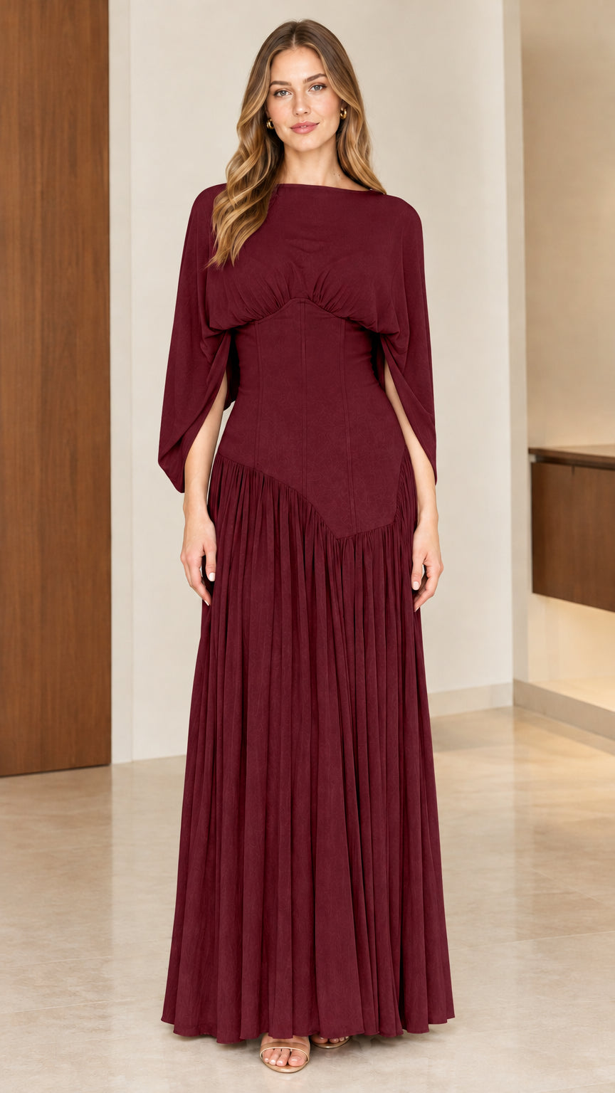 Full-length front view of model wearing burgundy wine corset waist pleated gown