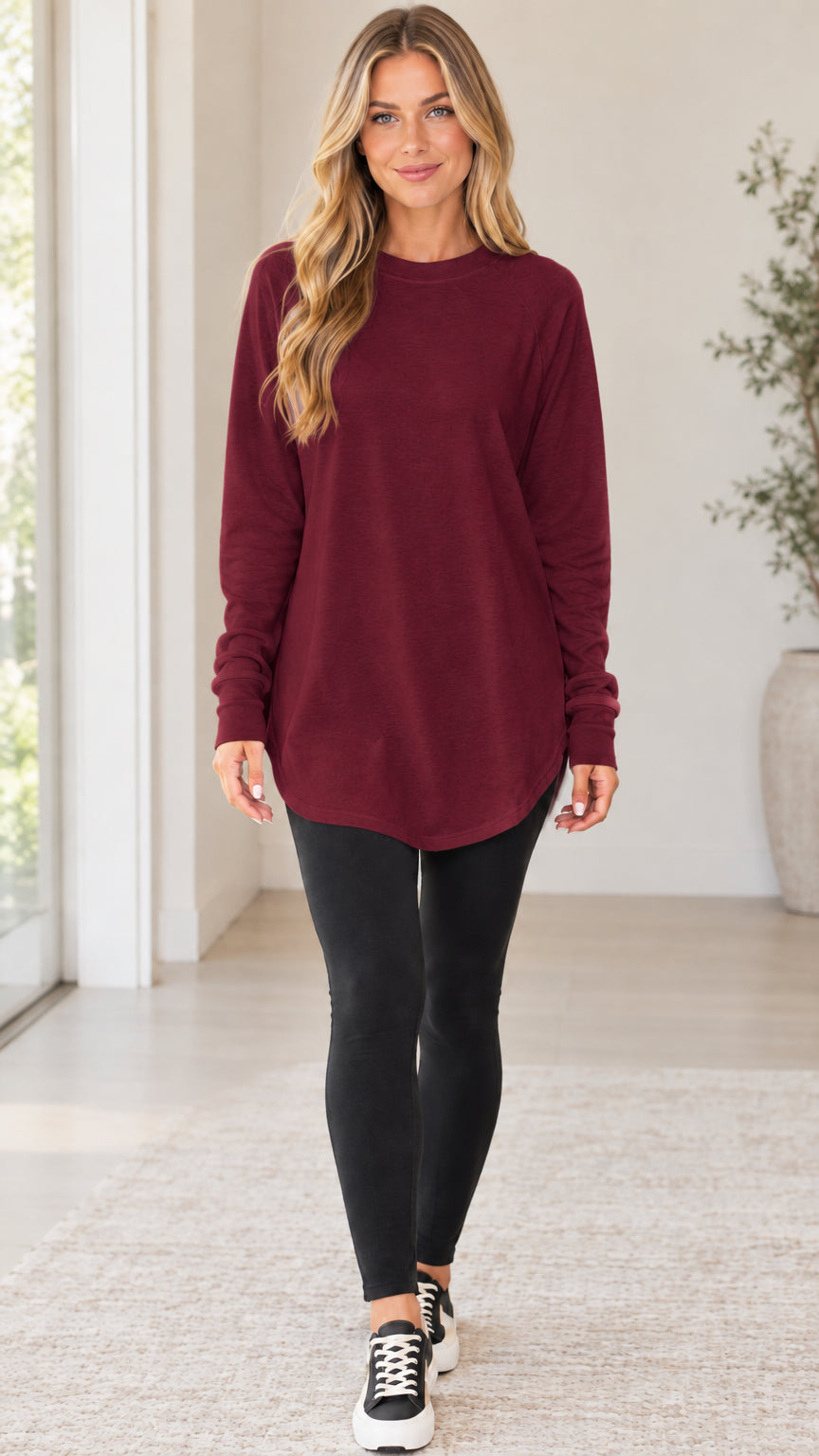 Front view of the burgundy wine red crewneck long sleeve tunic top styled with leggings