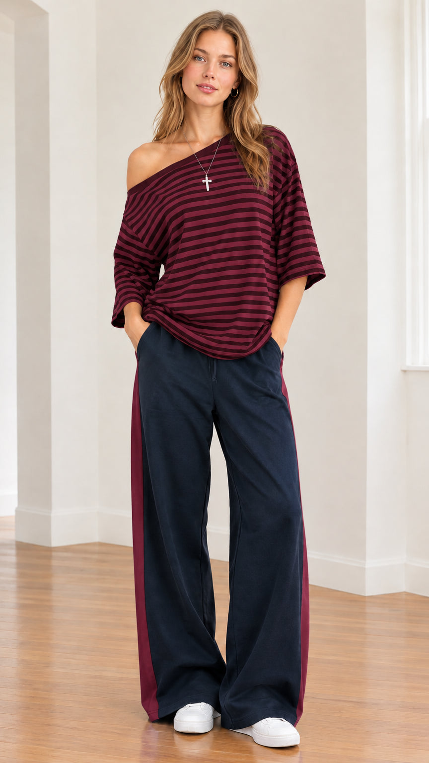 Model wearing burgundy striped one-shoulder top paired with matching burgundy side-stripe pants