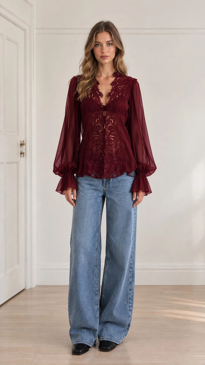 Model wearing burgundy red floral lace long sleeve blouse paired with wide-leg blue jeans
