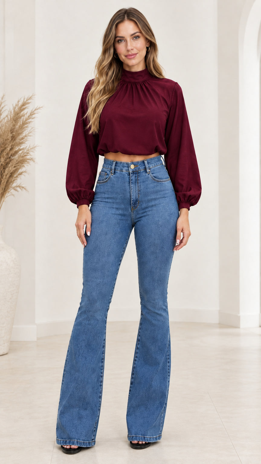 Front view of model wearing burgundy wine high neck crop top with high waist flare jeans
