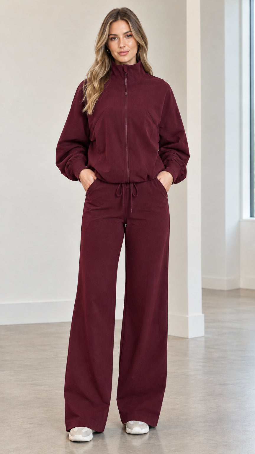Front full view of woman wearing burgundy wine zip-up track jacket and matching wide-leg pants