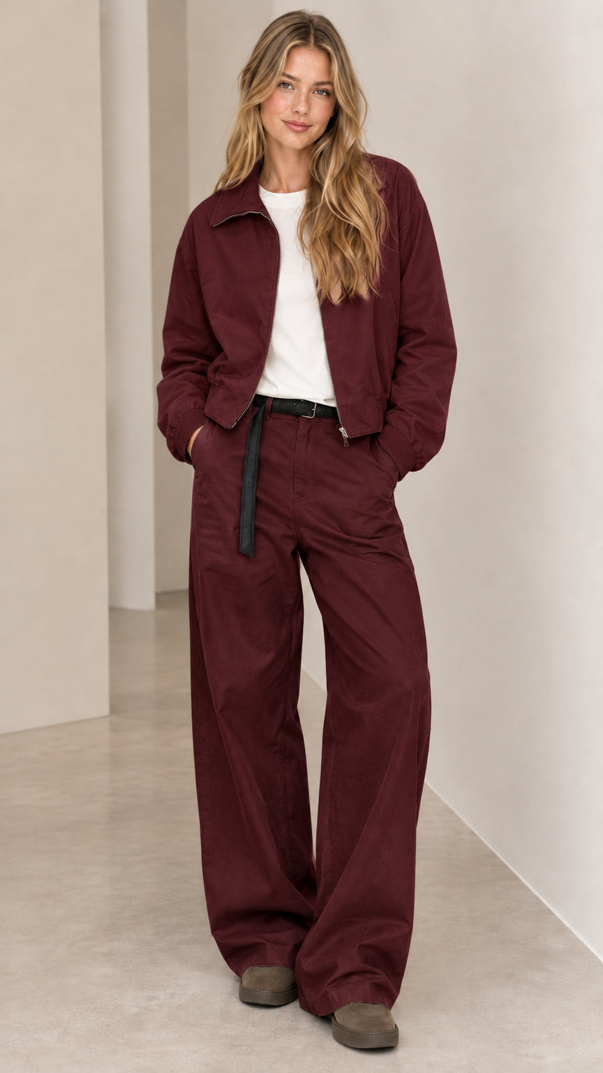 Front full view of woman wearing burgundy zip-front bomber jacket and wide-leg pants set