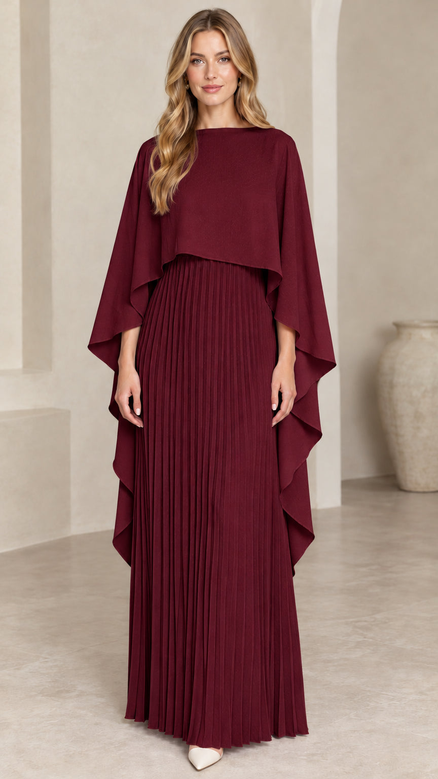 Front view of woman wearing burgundy wine pleated cape maxi dress