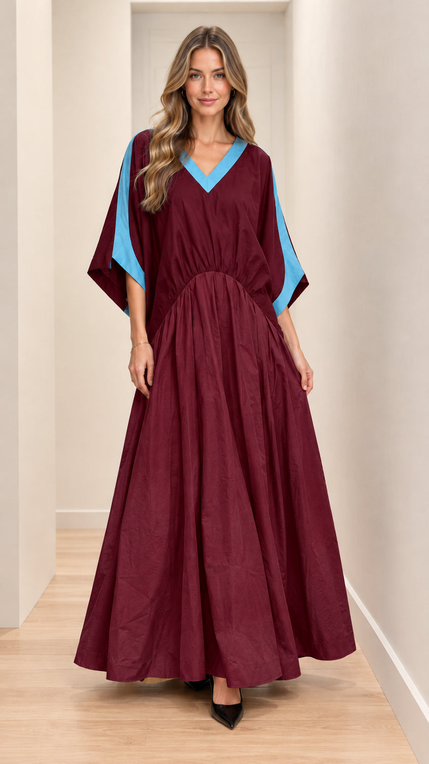 Front full-length view of model wearing burgundy maxi dress with blue contrast trim