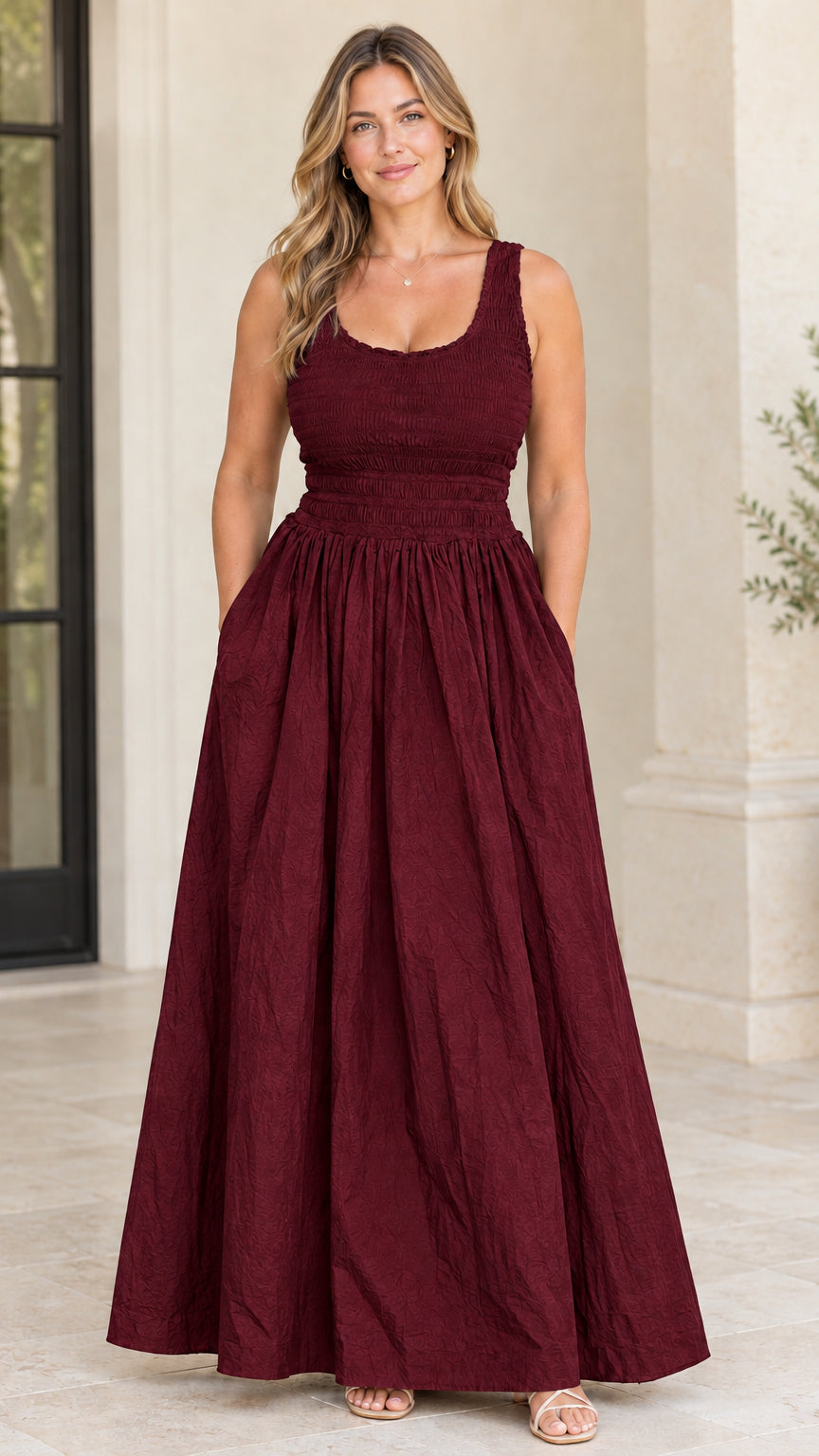 Model wearing burgundy wine red sleeveless smocked bodice maxi dress with pockets