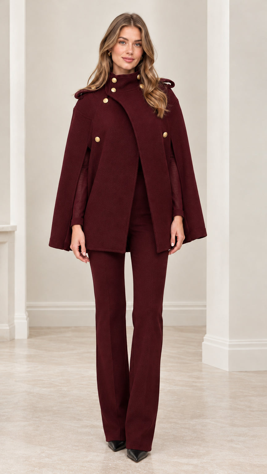 Front view of model wearing rich burgundy military cape coat with matching burgundy trousers