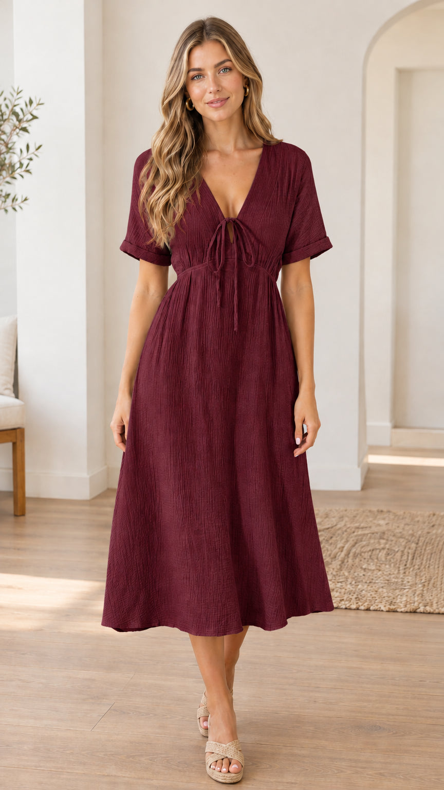 Front view of woman wearing burgundy wine red textured V-neck tie-front midi dress