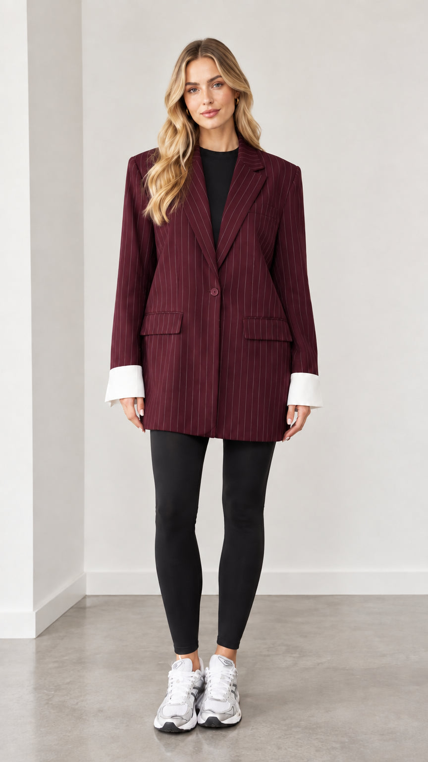 Front view of woman wearing burgundy wine pinstripe oversized blazer with white cuffs