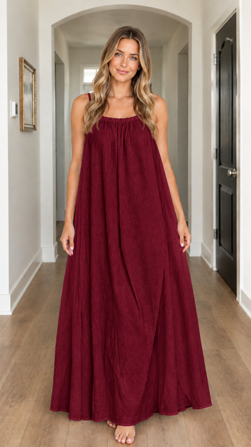 Model wearing burgundy gathered spaghetti strap floor-length dress